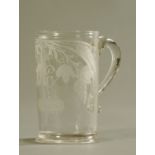 A large late 18th/early 19th century glass mug, foliate engraved and bearing initials.