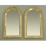 A pair of Italian arch topped mirrors, faceted and with brass mounts. Height 114 cm, width 62.5 cm.