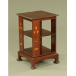 An early 20th century Arts and Crafts square revolving bookcase, inlaid with stylised motifs.