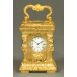 A miniature carriage clock, in the Rococo style, with caryatid figures to each corner.