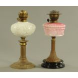 Two Victorian oil lamps, one with pink reservoir the other opaque.