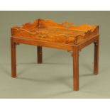 A George III mahogany butlers tray on associated coffee table stand, with corner spandrels.