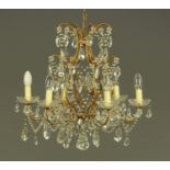 A gilt painted metal and faceted glass six branch candelabra, with faceted drops.