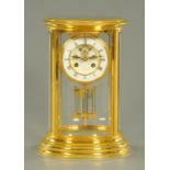 A gilded brass four glass clock, of oval form,