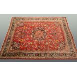 A large Eastern Persian design carpet with fringed ends, principal colours red, blue and beige,