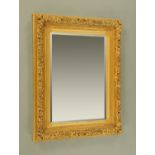 A gilt framed mirror, painted wood and composition, with bevelled glass.