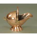 A Victorian copper helmet shaped coal scuttle, supported upon a circular base, 30 cm high.