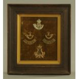 Durham Light Infantry, four mounted badges in oak frame, external dimensions 26 cm x 24 cm.