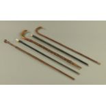 Five walking sticks and canes, one with faceted silver mount, Birmingham 1922,