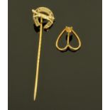An Edwardian gold coloured metal stick pin, surmounted by a fox and horseshoe,