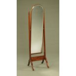 A mahogany framed tall cheval mirror, with bevelled glass, angled supports and downswept legs.