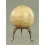 A polished marble sphere, off cream colour with natural inclusions and supported upon a brass stand,