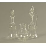 Two glass decanters each with stopper, together with a milk jug.