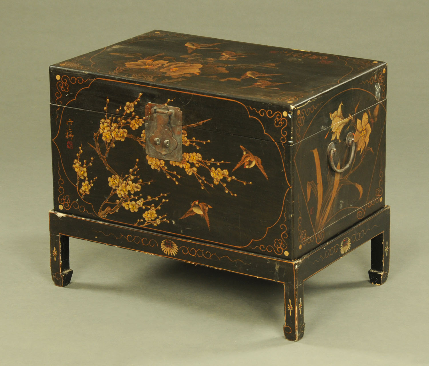 A Chinese lacquered box on stand, painted with lilies and with character marks to the reverse.