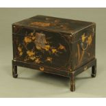 A Chinese lacquered box on stand, painted with lilies and with character marks to the reverse.