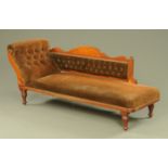 An Edwardian chaise longue, upholstered in brown corded material and with exposed showframe.