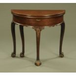 A George III mahogany demi lune turn over top card table,