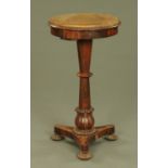 A William IV rosewood stand, with circular top, turned column, triform base and lobed bun feet.