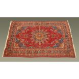 A Persian design fringed carpet, principal colours red,
