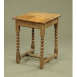 An antique oak table, with moulded edge and raised on bobbin turned legs with single stretcher.
