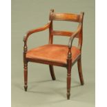 A Regency mahogany carver armchair, with stuffover seat and raised on turned legs.