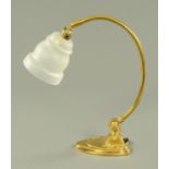 An adjustable brass desk lamp, with frosted glass shade on ball socket,