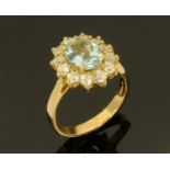 An 18 ct gold aquamarine and diamond cluster ring, yellow gold, aquamarine +/- 1.