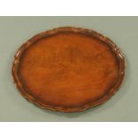 A George III style mahogany piecrust tray, 48 cm diameter.