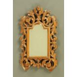 A Venetian carved wooden framed mirror, with bevelled glass. Height 47 cm, width 27 cm.