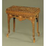 An early 20th century Middle Eastern Moorish design fold over games table,