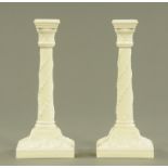 A pair of Royal Worcester porcelain candlesticks with moulded classical design,