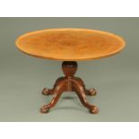 A burr walnut circular low occasional table, with moulded edge and turned column,