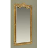 A large gilt framed mirror, with moulded shell and swag head and moulded frame, with bevelled glass.
