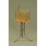 A brass and oak magazine rack, with carrying handle. Height 67 cm, width 35.5 cm.