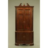 A George III style mahogany standing corner cupboard,