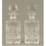 A pair of cut glass spirit decanters, 20th century, each with faceted knop and square bodies,