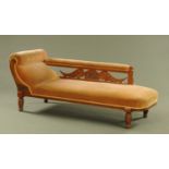 A late Victorian carved oak chaise longue, with bolster end,