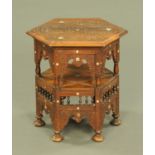 An Eastern carved wooden and inlaid bone hexagonal occasional table, raised on bun feet.