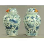 A pair of Oriental lidded vases, of large form with metal loop handles to the lid.