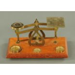 A set of lacquered brass postal scales, 20th century, warranted correct with stacking weights,