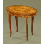 An Italian oval low worktable, with musical movement and raised on cabriole legs. Width 56 cm.