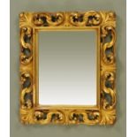 A giltwood wall mirror, with scrolling pierced frame and moulded inner edge.