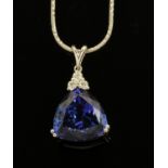 An 18 ct white gold pendant on chain, set with a trilliant cut Tanzanite with diamonds to the bale,
