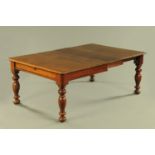 A Victorian mahogany extending dining table, with two leaves,