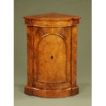 A Victorian walnut corner cupboard, bow fronted and inlaid and enclosing shelves. Width 63 cm.