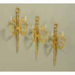 Three brass wall light fittings, in the Classical style, with rams heads.