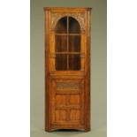 An Ipswich oak standing corner cupboard Siesta for Chapmans, foliate and scroll carved,