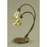 An Arts and Crafts metal table lamp, with two glass shades and water lily leaf base, height 39 cm.