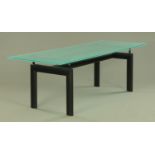 A Corbusier design dining table, with glass top and painted wooden end supports.