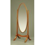 A mahogany framed oval cheval mirror, with inverted tapering supports and downswept legs.
